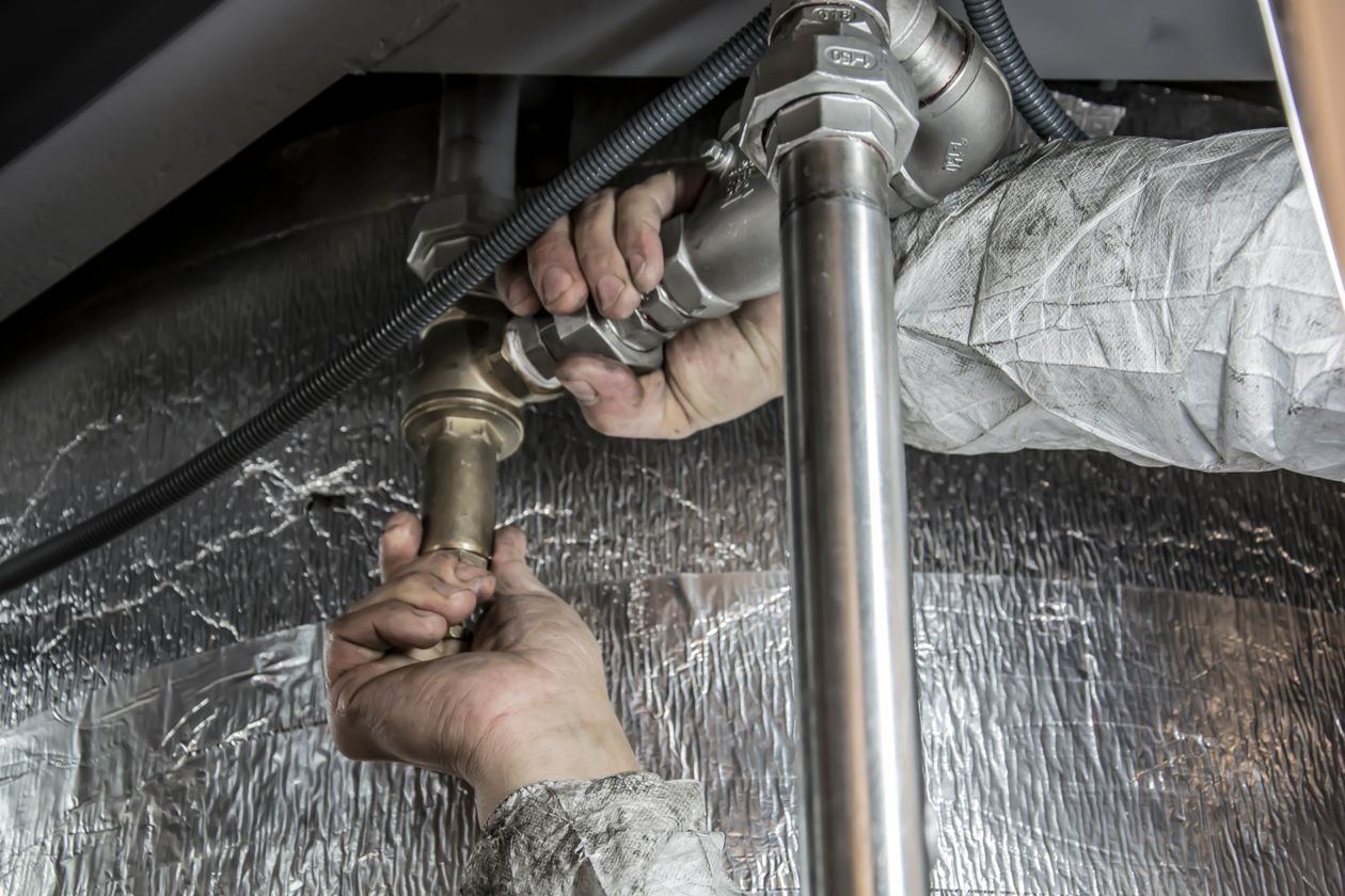 Plumber's hands fitting steel pipes during an installation